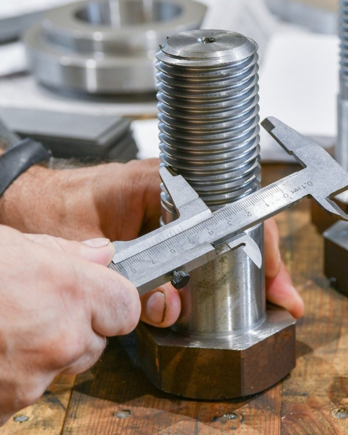 Fastener quality inspection — caliper measuring bolt dimensions and Rockwell hardness testing